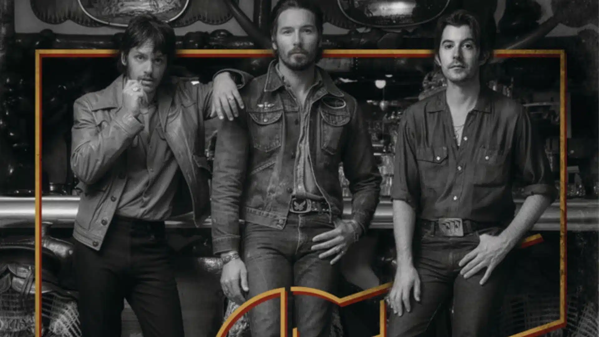 The three members of Midland posing together in denim and western wear against a vintage backdrop.