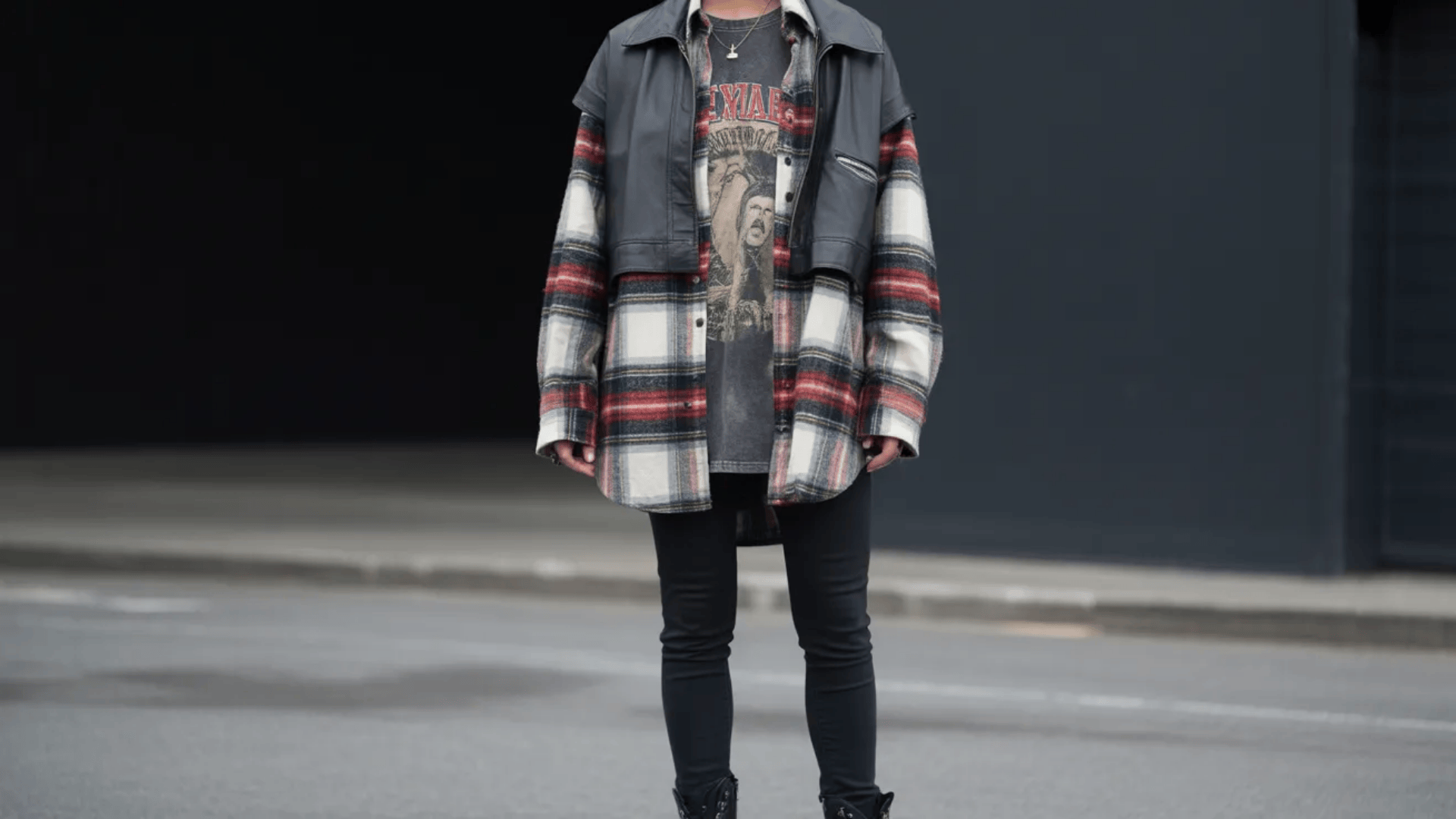 Indie sleaze outfit featuring an oversized plaid flannel layered over a vintage band tee, topped with a cropped leather jacket and paired with black skinny jeans for a grunge-inspired street look