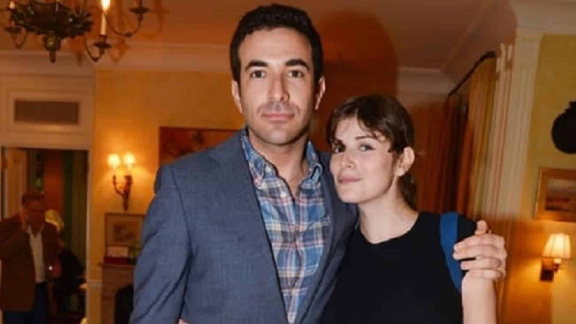 Ari melber with drew grant posing together indoors in a warmly lit setting