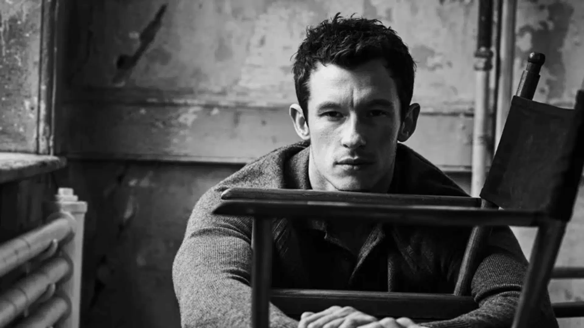 Black-and-white portrait of Callum Turner indoors.