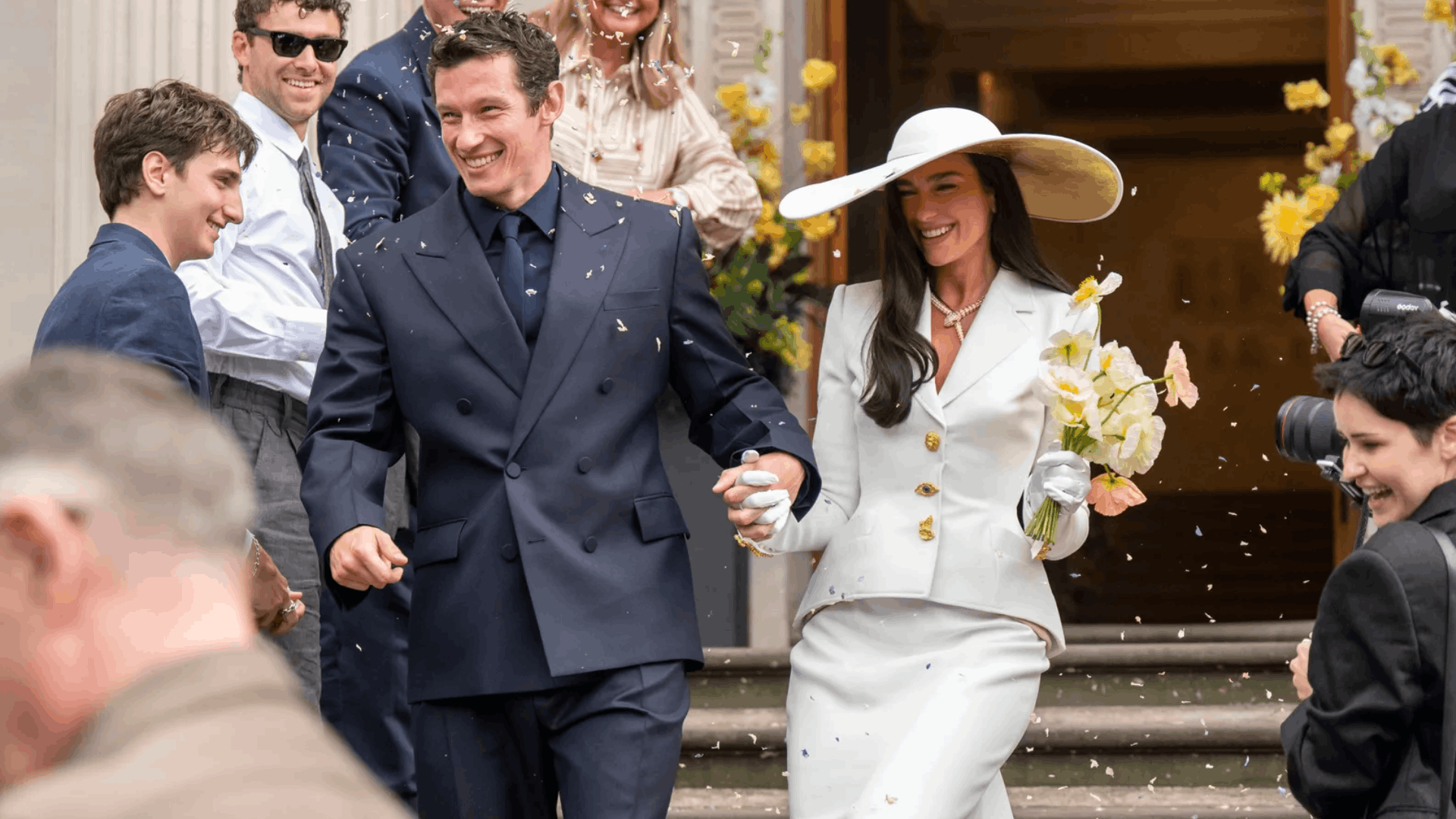 Dua Lipa and Callum Turner leaving their wedding ceremony amid confetti.