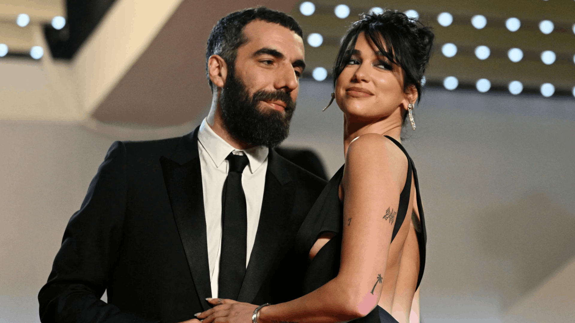 Dua Lipa with filmmaker Romain Gavras at a red carpet event.