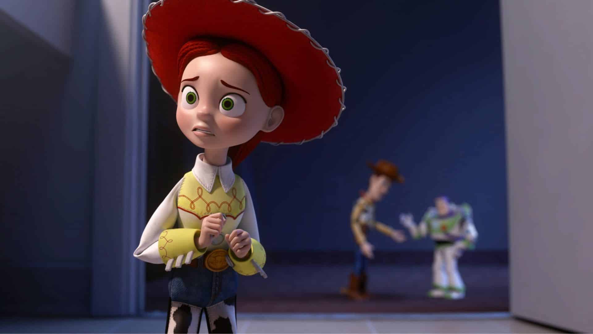 Jessie the cowgirl toy looks worried while standing in a doorway, with Woody and Buzz Lightyear blurred in the background.