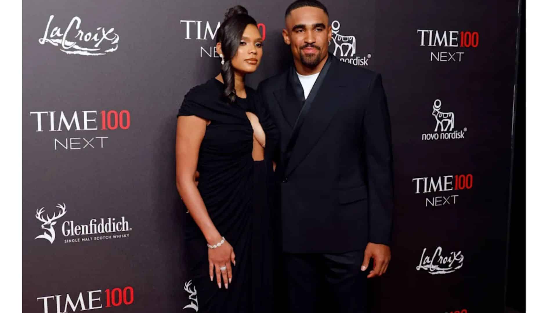 Bry Burrows and Jalen Hurts pose together on the red carpet at the Time100 Next Gala, wearing coordinated black formal outfits.