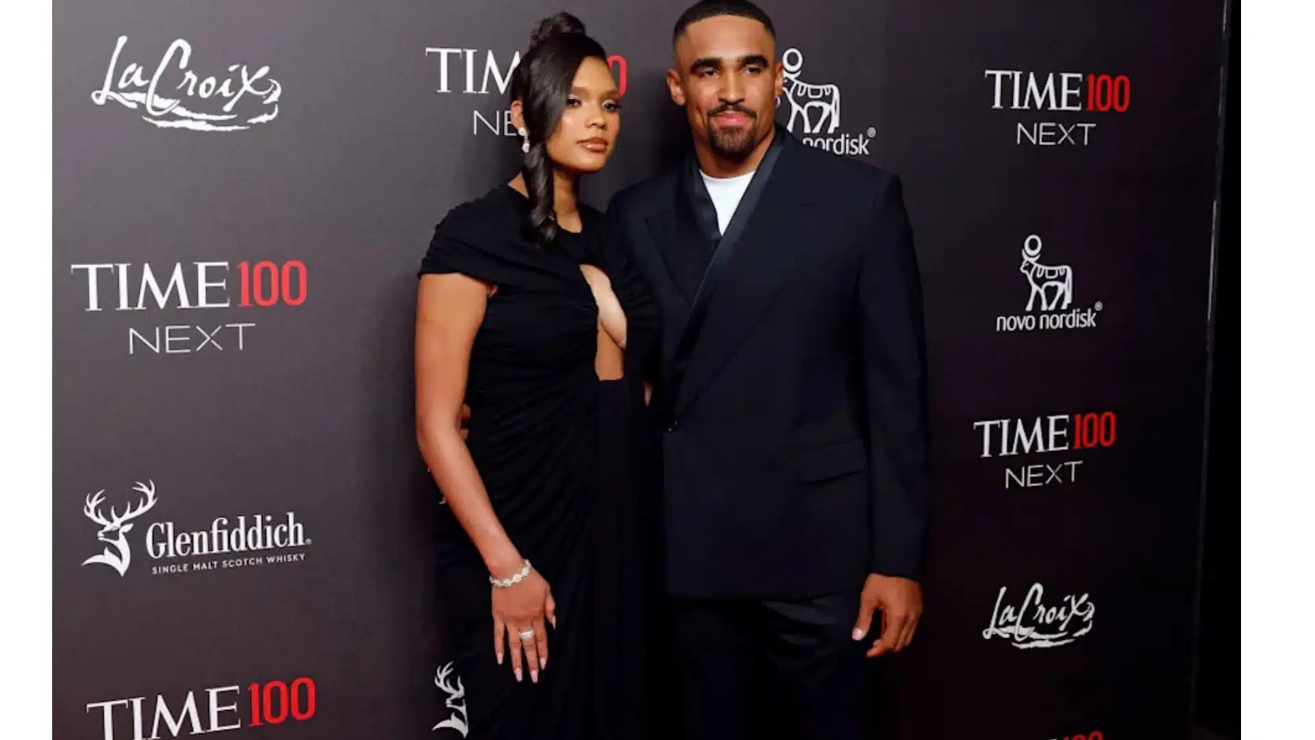 Bry Burrows and Jalen Hurts pose together on the red carpet at the Time100 Next Gala, wearing coordinated black formal outfits.
