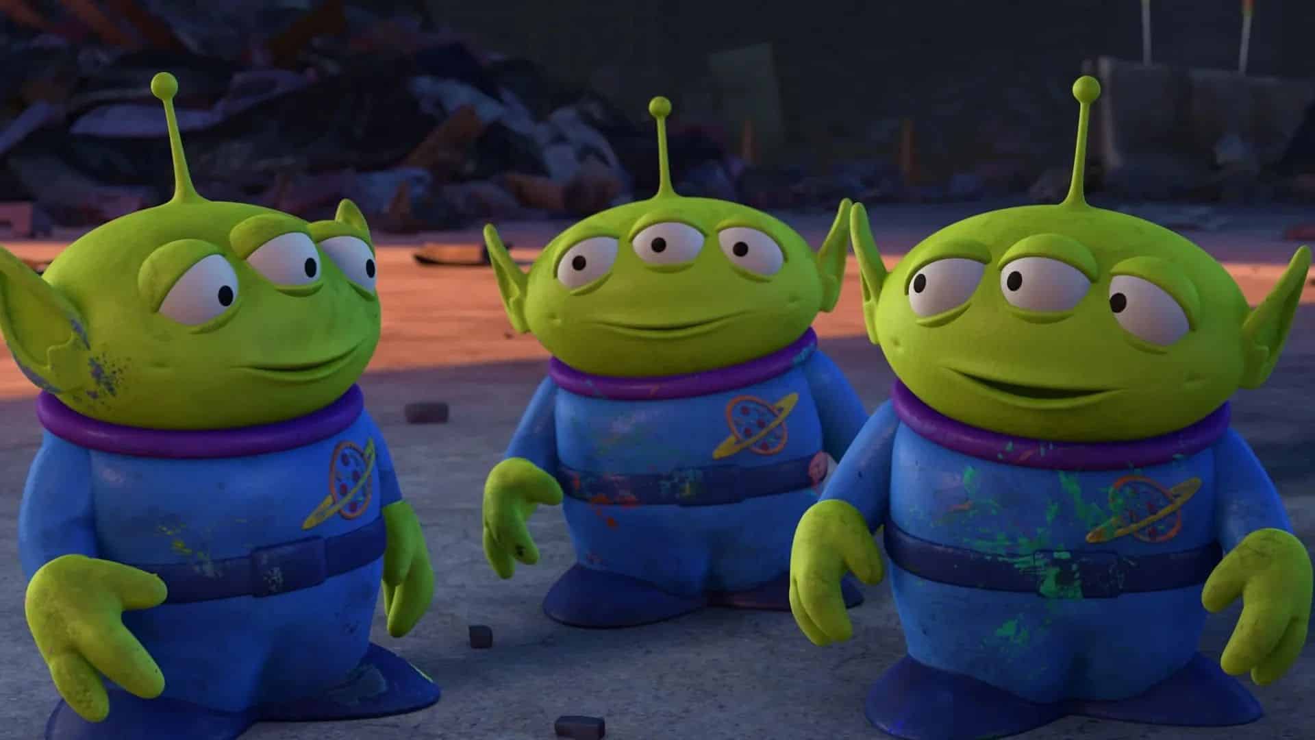 The three green alien toys from Toy Story standing together in their blue space uniforms.