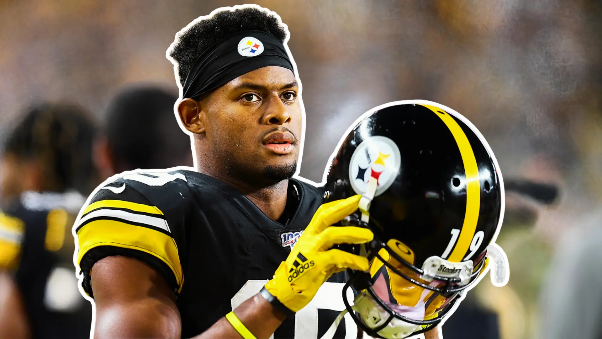 JuJu Smith-Schuster in Pittsburgh Steelers uniform holding his helmet on the sideline.